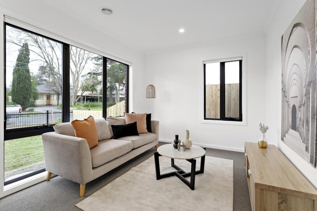 Open living area with large windows and timber flooring in a Byron Road custom home by Brownhill Homes