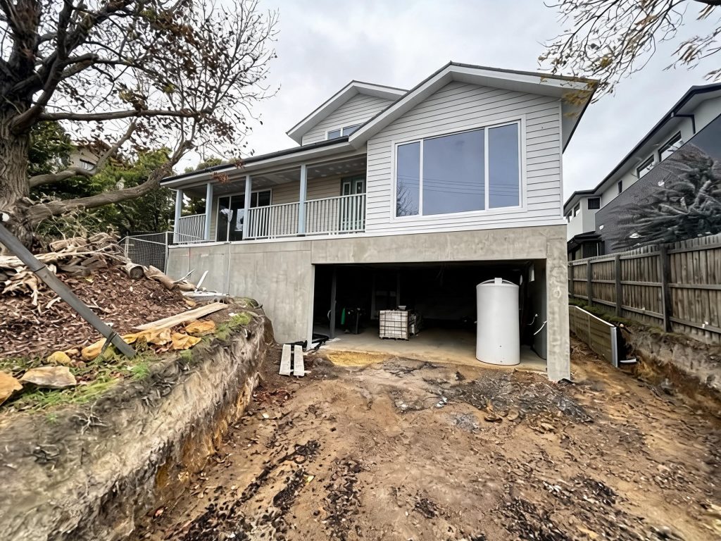 Custom home under construction on a steep block